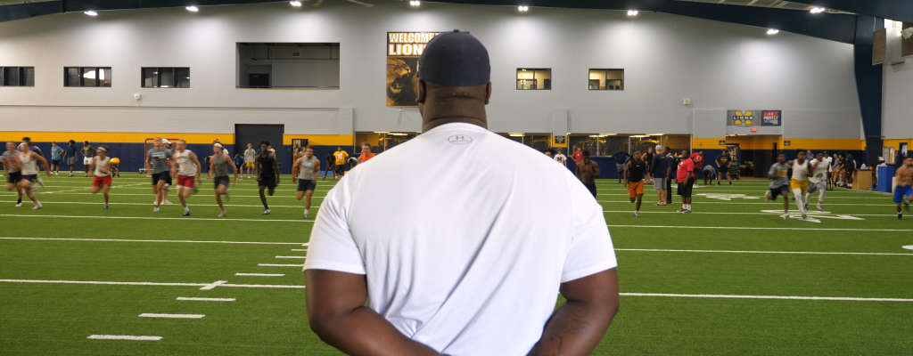 coach marcus shavers leading an indoor football practice at McKinny High Schol