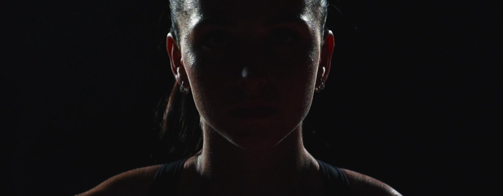 Dramatic lighting of female athlete representing practice of mental skills